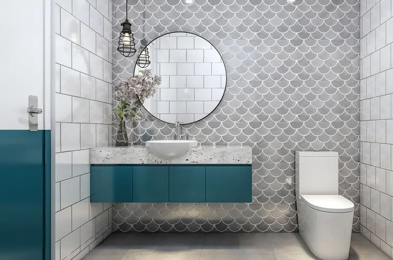 Bức tường hình vảy cá cùng kệ màu xanh tạo nên sự hài hòa cho phòng tắm