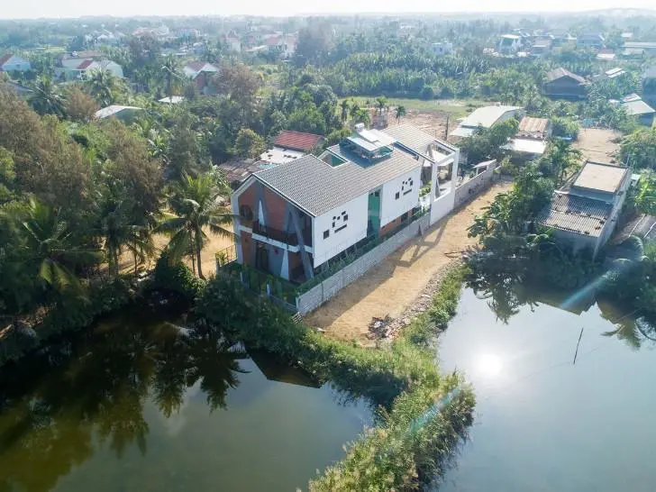 Ngôi nhà mang hình ảnh chữ A được bao bọc xung quanh bởi ao hồ, cây xanh