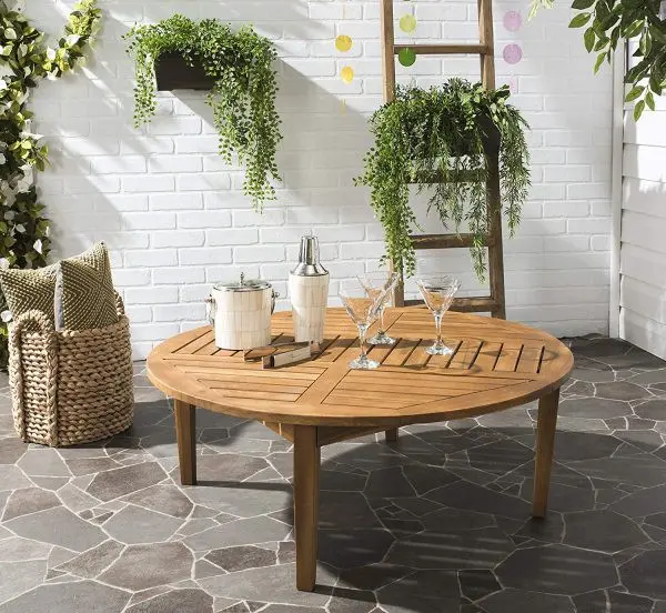 Một kiểu bàn gỗ hình tròn đã qua xử lý để chống chịu được thời tiết bên ngoài