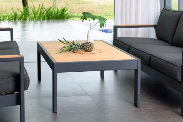 Bàn cà phê ngoài trời có khung màu đen với mặt trên bằng gỗ tếch tự nhiên, tạo nên sự tương phản đẹp mắt