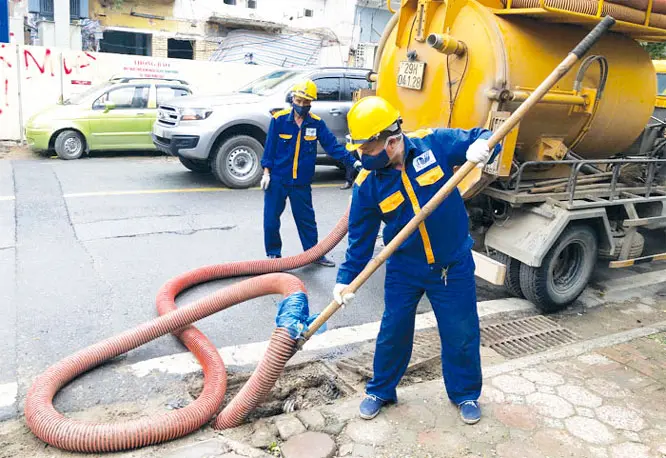 Công nhân Công ty Thoát nước nạo vét cống tại ngã ba Phan Bội Châu - Trần Hưng Đạo (gần Ga S12, thuộc Dự án đường sắt đô thị Hà Nội, đoạn Nhổn - Ga Hà Nội)