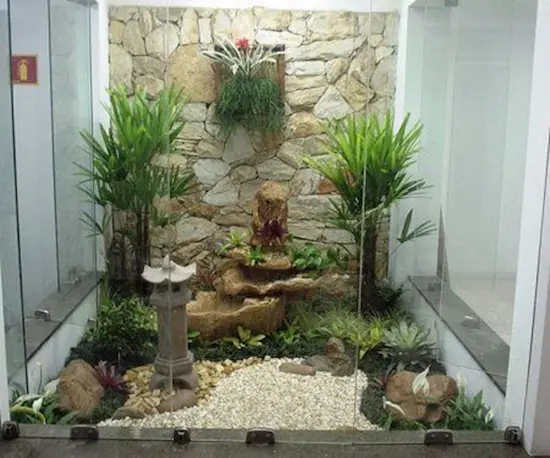Sân vườn nhỏ theo phong cách Nhật Bản có đèn đá, đá sỏi và cây xanh.