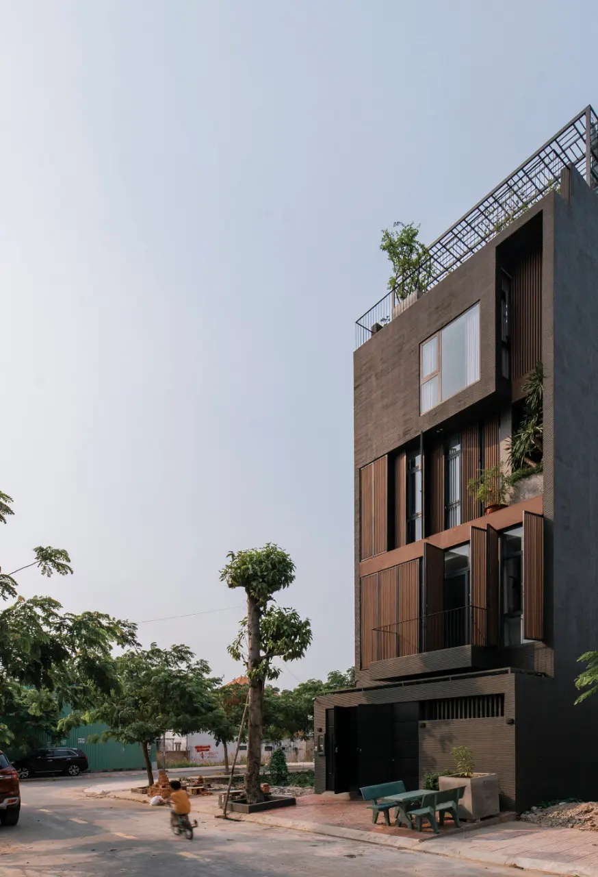 Mặt tiền của căn nhà được thiết kế với 2 lớp: lớp thứ nhất là lam gỗ, lớp thứ hai là cửa kính