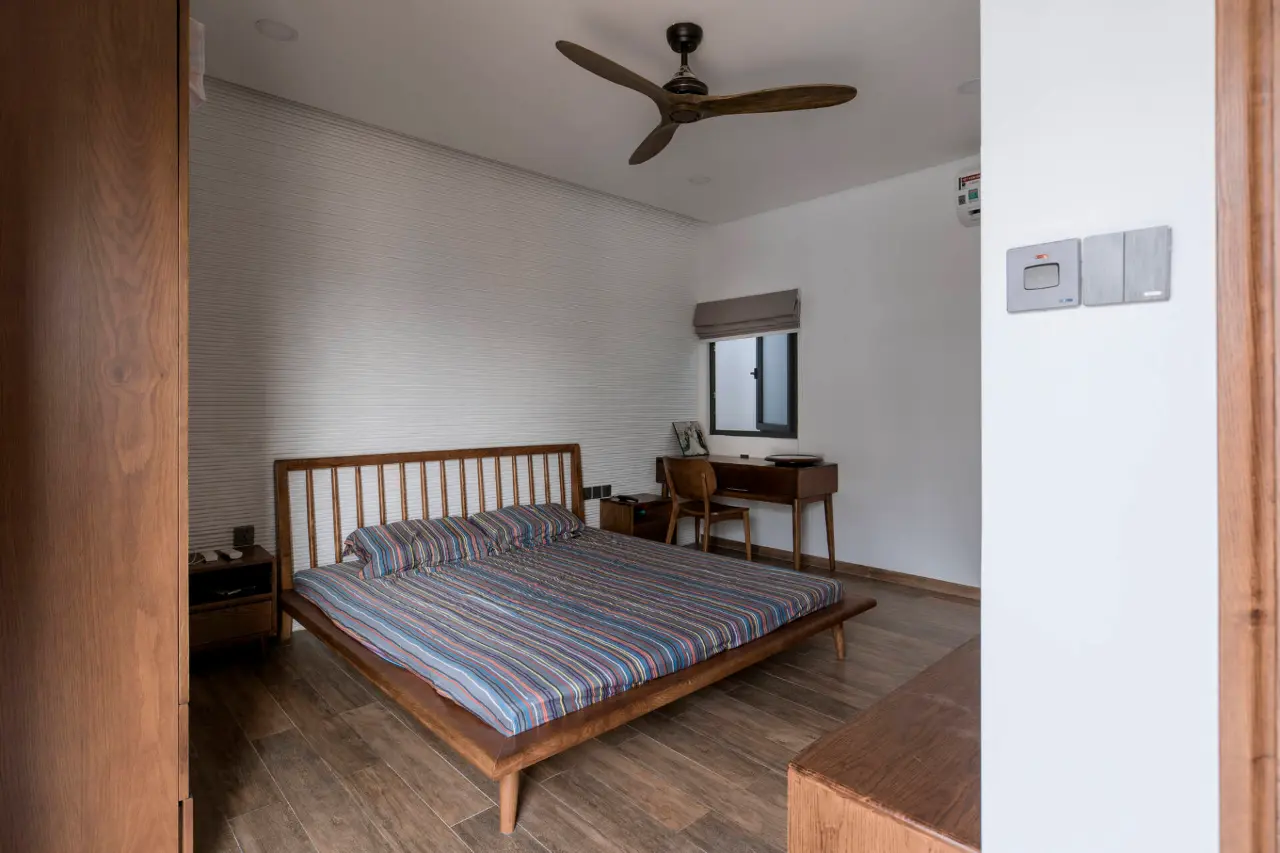 Với những phòng ngủ không có mặt thoáng hướng ra bên ngoài, KTS đã tận dụng khoảng giếng trời với ô cửa sổ nhỏ. Phòng không có nhiều đồ đạc và được sắp xếp gọn gàng