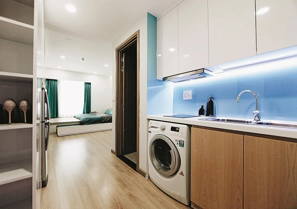 Khu bếp nấu nằm kế bên phòng vệ sinh ở lối vào, tuy rất nhỏ nhưng vẫn đủ các chức năng cần thiết. Máy giặt được bố trí ở tủ bếp dưới.