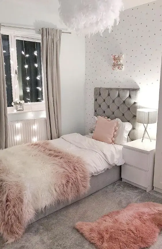 Ý tưởng decor phòng ngủ nhỏ với cách bố trí thảm trải sàn và thảm trang trí bằng lông thú. Tường được dán giấy màu sắc nhẹ nhàng, hệ thống đèn dây thả được thiết kế dọc theo cửa sổ, mang đến sức sống và sự cân bằng ánh sáng nghệ thuật cho căn phòng nhỏ.