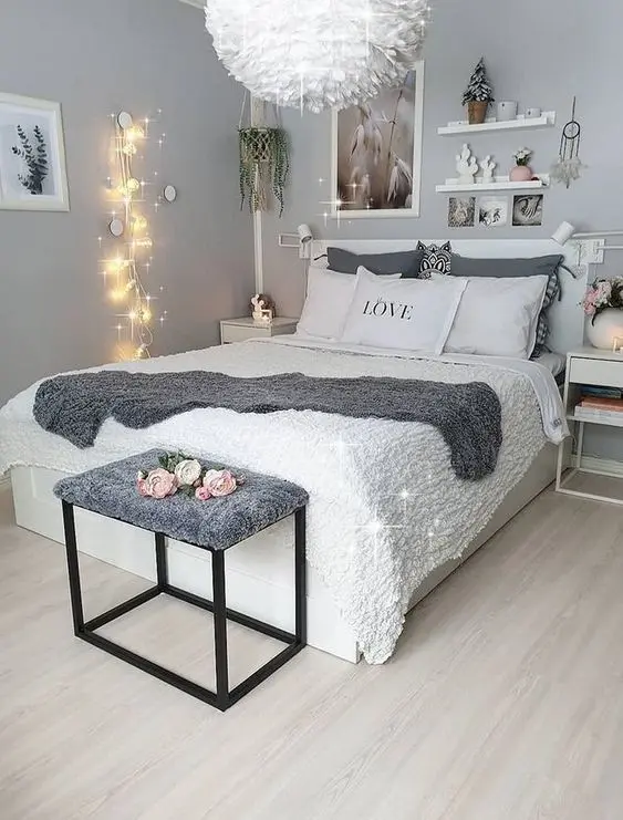 Phòng ngủ nhỏ lên ý tưởng với hệ thống đèn thả khối tròn đẹp mắt. Đầu giường trang trí nổi bật với kệ treo nhỏ, đèn dây gắn tường và tab hai bên đầu giường tích hợp hộc tủ chứa đồ, có thể tận dụng để chứa sách báo. Tông màu trắng kết hợp với sơn tường màu ghi xám, sức hút của không gian càng thêm mới mẻ.