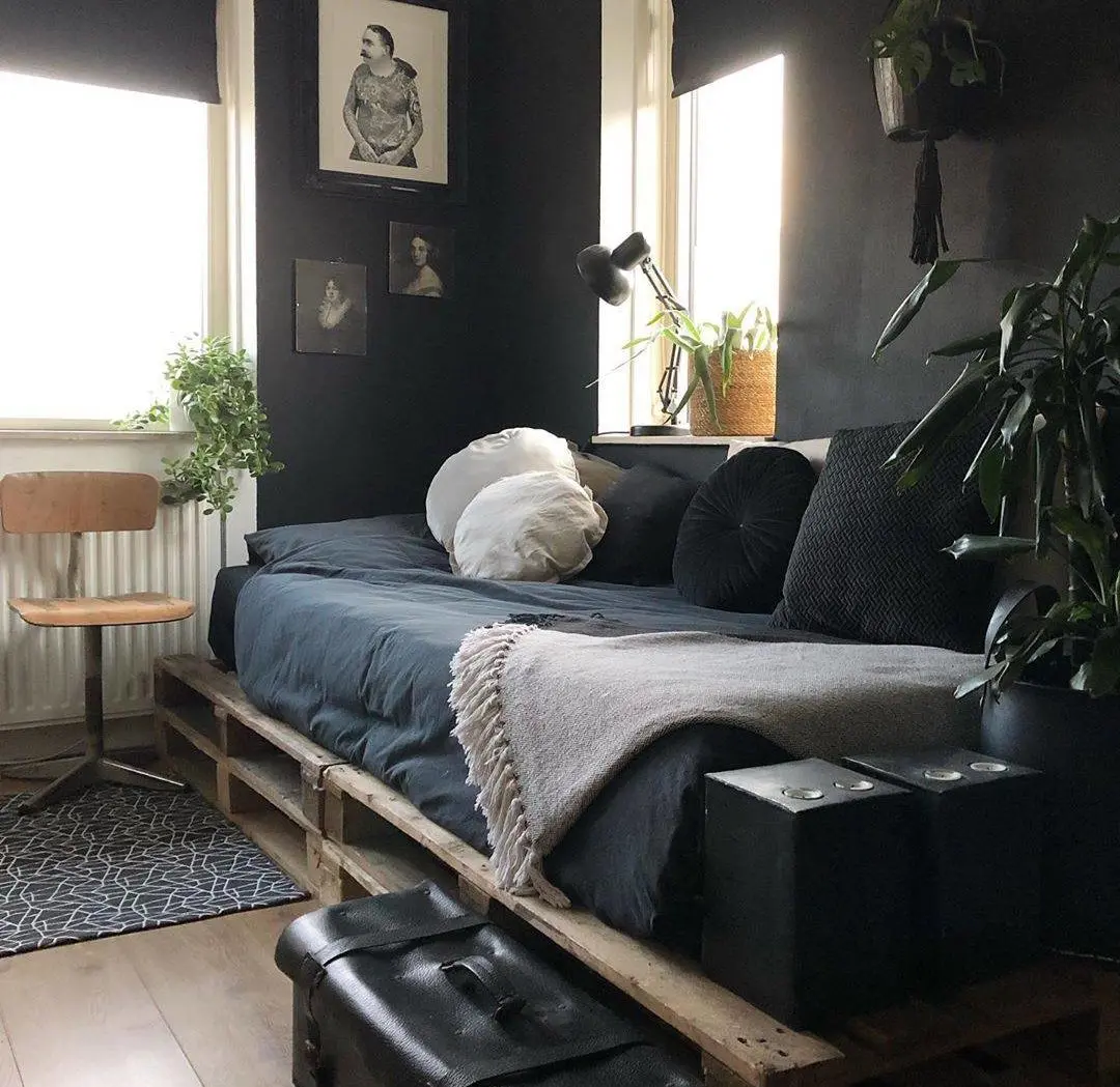Căn phòng màu bão được hoàn thiện với một chiếc giường ban ngày bằng pallet bằng gỗ mộc mạc tự nhiên