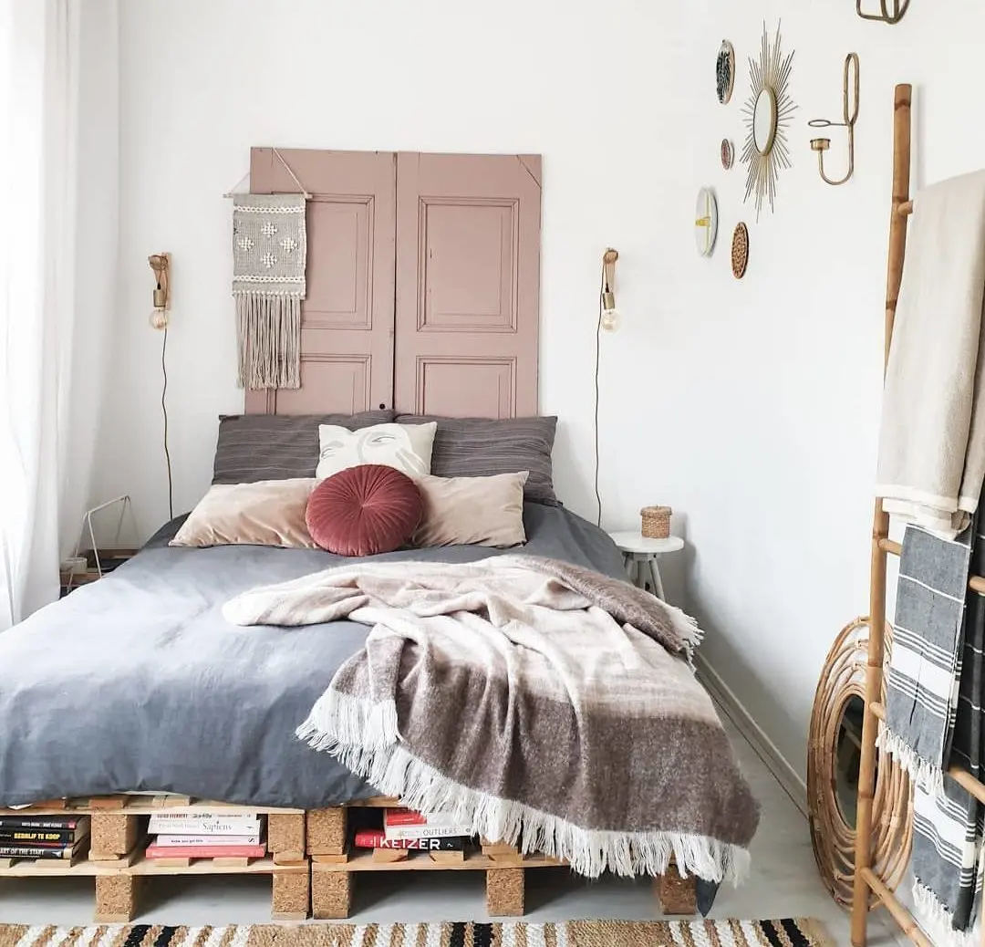 Các pallet xếp chồng đôi làm bằng ván dăm đóng vai trò vừa là nơi lưu trữ vừa là khung giường theo phong cách mộc mạc trong căn phòng boho đồng quê này
