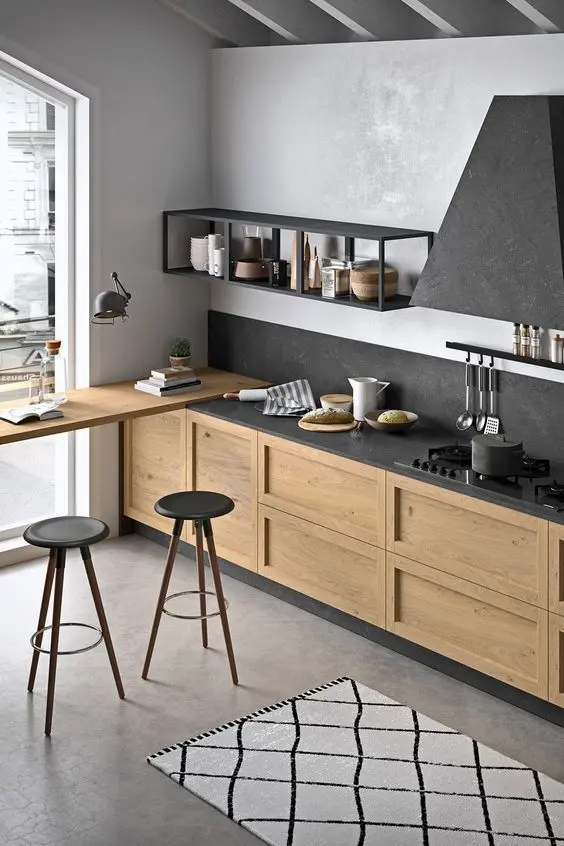 một nhà bếp hiện đại đầy phong cách với tủ màu sáng, mặt bàn bằng đá đen, tấm ốp nền và máy hút mùi