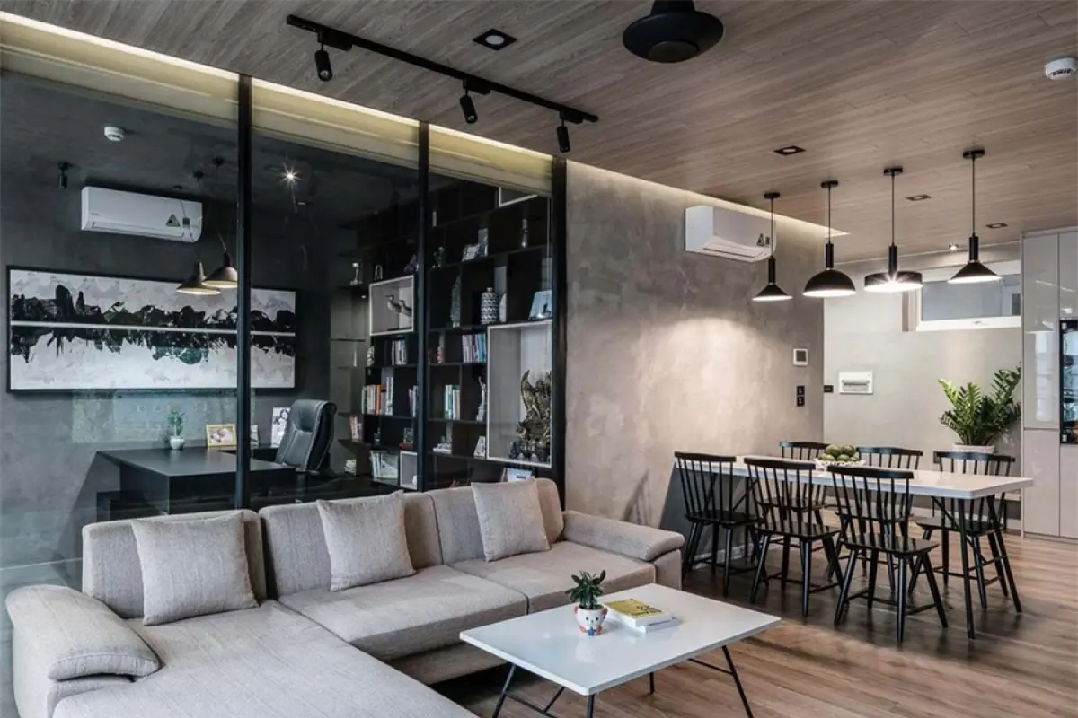 Phòng làm việc nằm sau lưng sofa ở phòng khách được ngăn cách bằng vách kính để tạo cảm giác thông thoáng.