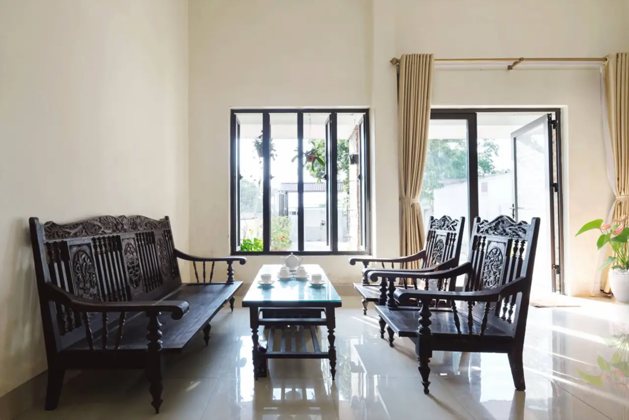 Phòng khách chính của ngôi nhà vẫn sử dụng bàn ghế cũ. Không gian này tràn ngập ánh sáng nhờ hệ cửa kính ở cửa chính và cửa sổ.